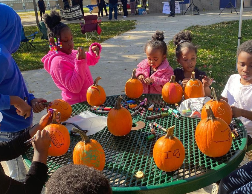 kids decorating pumpkins in a park
